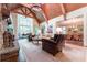 Bright living room featuring a stone fireplace, vaulted ceiling with wood beams, and large windows at 2167 W Wesley Nw Rd, Atlanta, GA 30327