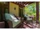 Cozy covered patio featuring wicker chairs and a view of lush green trees in a wooded backyard at 2167 W Wesley Nw Rd, Atlanta, GA 30327