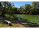 Peaceful river view featuring mature trees and a rustic bench along the bank at 2167 W Wesley Nw Rd, Atlanta, GA 30327