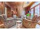 Comfortable sitting room with wood paneling, multiple armchairs, a round ottoman, and french doors at 2167 W Wesley Nw Rd, Atlanta, GA 30327