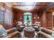 Cozy wood paneled sitting room with four armchairs, an ottoman, arched windows, and natural light at 2167 W Wesley Nw Rd, Atlanta, GA 30327