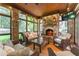Inviting sunroom with stone fireplace, comfortable seating, and views of the lush outdoor scenery at 2167 W Wesley Nw Rd, Atlanta, GA 30327