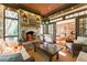 Relaxing sunroom featuring a stone fireplace, comfortable furniture, and access to the main living area at 2167 W Wesley Nw Rd, Atlanta, GA 30327