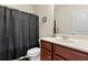 Clean bathroom with a dark wood vanity, toilet, and shower with a black curtain at 550 Breton Highlands, Fairburn, GA 30213