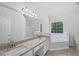 Bright bathroom featuring double sinks, granite countertops, and a separate tub at 10924 Hondal Ct, Hampton, GA 30228
