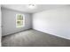 Bedroom with neutral carpet, white walls, and a window offering natural light at 10924 Hondal Ct, Hampton, GA 30228