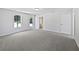 Spacious bedroom with gray carpet, a window, and doors, offering a peaceful retreat with natural light and backyard access at 10924 Hondal Ct, Hampton, GA 30228