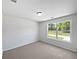 Bedroom with neutral carpet and a large window that provides a view of the front yard at 10924 Hondal Ct, Hampton, GA 30228