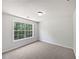 Bedroom with neutral carpet, a large window overlooking trees, and white walls at 10924 Hondal Ct, Hampton, GA 30228