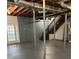 Open basement featuring painted floors, support beams, and a staircase, presenting a versatile space at 2000 Hill Rd, Marietta, GA 30062