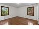 Empty bedroom with wood floors and natural light from two large windows overlooking yard at 2000 Hill Rd, Marietta, GA 30062