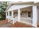 Charming covered front porch featuring brick accents, white pillars, and a cozy entrance, creating a welcoming atmosphere at 2000 Hill Rd, Marietta, GA 30062