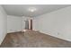 Open living room with neutral carpet, white trim, and visible access to other areas of the house at 2000 Hill Rd, Marietta, GA 30062