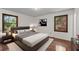 Staged main bedroom with wood floors, furniture, and natural light from large windows at 2000 Hill Rd, Marietta, GA 30062