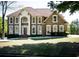 Traditional brick home with manicured lawn, columns, and arched entryway providing classic curb appeal at 2328 New Haven Pl, Conyers, GA 30094
