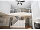 Bright, open-concept living area with a soaring ceiling, fireplace, and upper-level balcony at 2328 New Haven Pl, Conyers, GA 30094