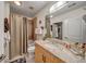 Bathroom with granite countertop, framed mirror, neutral shower curtain, and tiled shower at 400 W Peachtree Nw St # 3114, Atlanta, GA 30308