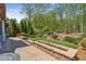 Paver patio featuring stone retaining walls looks out on beautiful landscaping and mature trees at 6382 Mountain Ridge Cir, Sugar Hill, GA 30518