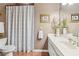 Well-lit bathroom featuring a shower/tub combo, a white sink and a decorative shower curtain at 6382 Mountain Ridge Cir, Sugar Hill, GA 30518