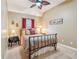 A small, quaint bedroom with decorative bedframe, ceiling fan, and small birdcage decorations at 6382 Mountain Ridge Cir, Sugar Hill, GA 30518