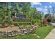 Stone sign for the Twin Creeks community with beautiful landscaping and mature trees at 6382 Mountain Ridge Cir, Sugar Hill, GA 30518