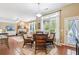 Open-concept dining area with wicker chairs, leading to the living room and bright outdoor views at 6382 Mountain Ridge Cir, Sugar Hill, GA 30518