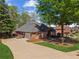 Brick home with driveway and attached garage, with mature trees and manicured lawn at 6382 Mountain Ridge Cir, Sugar Hill, GA 30518