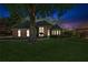 Brick home with large front yard featuring a mature tree, lit for nighttime appeal at 6382 Mountain Ridge Cir, Sugar Hill, GA 30518