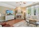 Bright living room with fireplace, tile flooring, a ceiling fan, and large windows at 6382 Mountain Ridge Cir, Sugar Hill, GA 30518