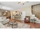 Bright living room featuring neutral tones, tile flooring, ceiling fan, and seamless access to the dining and kitchen areas at 6382 Mountain Ridge Cir, Sugar Hill, GA 30518