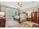 Elegant main bedroom with neutral tones, ceiling fan, large windows, and decorative furniture at 6382 Mountain Ridge Cir, Sugar Hill, GA 30518
