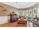 A well-lit sitting room with large bay windows, decorative furniture and neutral color palette at 6382 Mountain Ridge Cir, Sugar Hill, GA 30518