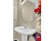 A bathroom with a pedestal sink, oval mirror, and neutral wall color at 984 Redwood Dr, Norcross, GA 30093