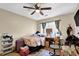 A bedroom with a ceiling fan, a window with curtains, and a bed with patterned covers at 984 Redwood Dr, Norcross, GA 30093