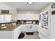 A kitchen featuring white cabinets, tiled backsplash, stone countertops, and modern appliances at 984 Redwood Dr, Norcross, GA 30093