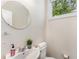 Bright powder room featuring a stylish round mirror, modern sink, and window with a view at 1390 Stirling Nw Cir, Atlanta, GA 30318