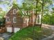 Side view of a brick home with a two-car garage and surrounding greenery at 1961 River Forest Rd, Atlanta, GA 30327