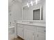 Well-lit bathroom featuring white cabinets, granite counters, modern fixtures, and a large mirror at 9174 Retreat Pass, Jonesboro, GA 30236