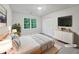 Airy staged bedroom featuring a neutral color palette, large window and light wood flooring at 9174 Retreat Pass, Jonesboro, GA 30236