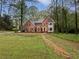 Beautiful brick home featuring a manicured lawn, mature trees and classic architectural details at 9174 Retreat Pass, Jonesboro, GA 30236