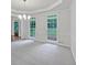 Light-filled living room featuring carpet, large windows, crown molding, and bright neutral colors at 9174 Retreat Pass, Jonesboro, GA 30236