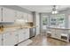 Bright eat-in kitchen featuring white cabinets, stainless steel dishwasher, and tile flooring at 2099 Winsburg Nw Way, Kennesaw, GA 30144