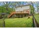 Spacious backyard with a wooden deck, stairs, and lush greenery, ideal for outdoor entertaining and relaxation at 2645 Sandstone Dr, Lawrenceville, GA 30043