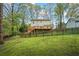 Backyard featuring a raised deck with stairs, offering an inviting outdoor living space surrounded by trees at 2645 Sandstone Dr, Lawrenceville, GA 30043