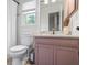 Cozy bathroom features a white toilet, modern faucet, with lavender cabinetry below a light countertop at 2645 Sandstone Dr, Lawrenceville, GA 30043