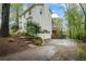 Two-story home with bay window, deck, and attached garage, nestled in a wooded area on a partially cloudy day at 2645 Sandstone Dr, Lawrenceville, GA 30043