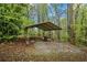 Metal-roofed shelter in a wooded area, providing a functional and sheltered outdoor space on gravel at 2645 Sandstone Dr, Lawrenceville, GA 30043