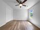 Bright bedroom features neutral walls, hardwood floors, a ceiling fan, a window, and a double-door closet at 41 Olde Town Way, Rockmart, GA 30153
