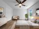 Cozy bedroom featuring neutral tones, hardwood floors, a ceiling fan, and a bright window; virtually staged at 41 Olde Town Way, Rockmart, GA 30153