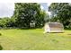 Large backyard featuring a shed, lush green lawn, and trees at 4424 Robinson St, Acworth, GA 30101